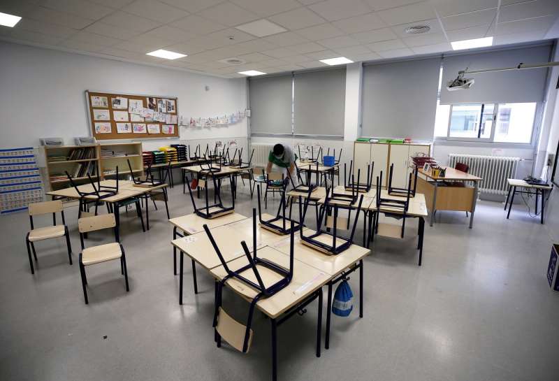 Imagen de archivo de una trabajadora del servicio de limpieza limpiando las sillas y los pupitres de una clase de infantil en un colegio valenciano. EFEManuel Bruque
