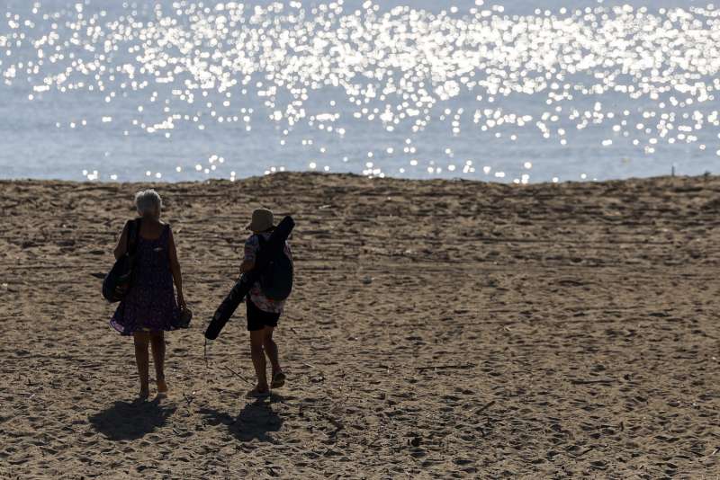 Dos personas se dirigen a la playa de El Saler, en Valencia, este mircoles. EFEKai Frsterling
