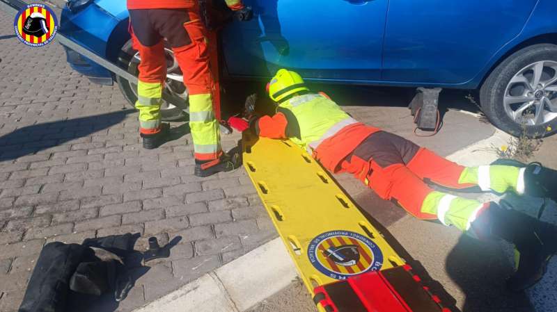 Imagen de rescate del conductor de un patinete de los bajos de un veh�culo en Torrent, facilitada por el Consorcio provincial de bomberos.  EFE

