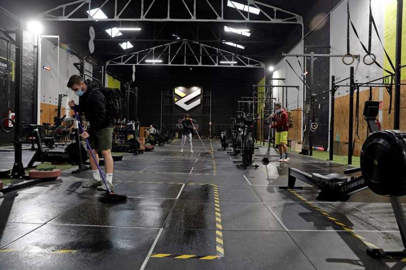 Operarios de un gimnasio en València desinfectan y recogen el local. EFE