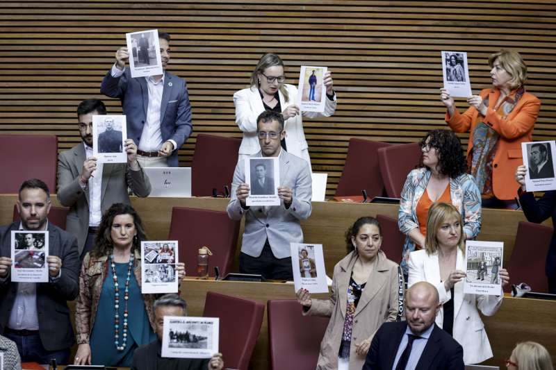 Los diputados socialistas muestran fotos de represaliados por la dictadura antes del comienzo del pleno de Les Corts. EFE/Biel Aliño

