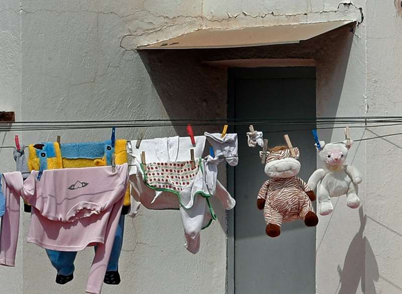 Ropa de niños junto a dos muñecos de peluche se secan al sol. EFE/ Juan Carlos Cárdenas/Archivo
