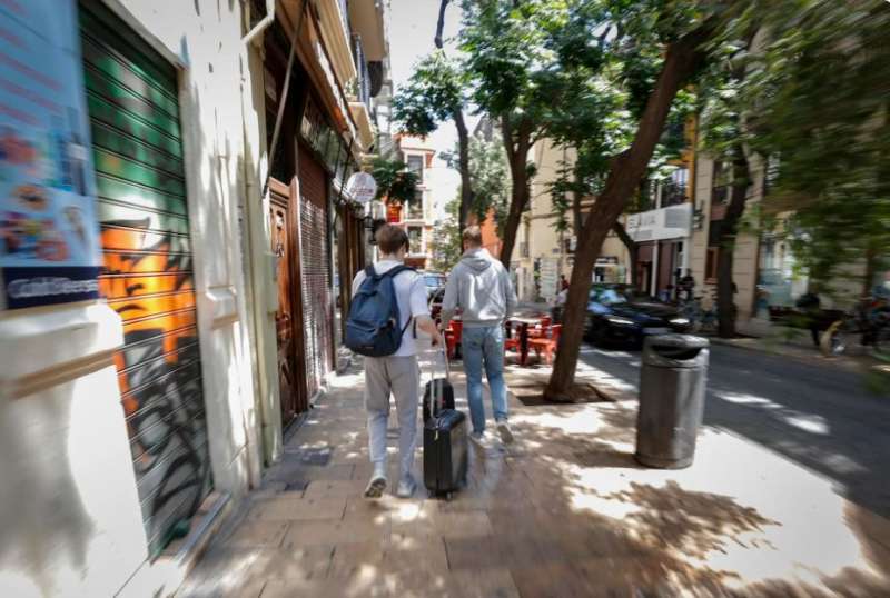 Dos turistas recorren con sus maletas el casco antiguo de la ciudad de Valencia. EFEManuel BruqueArchivo

