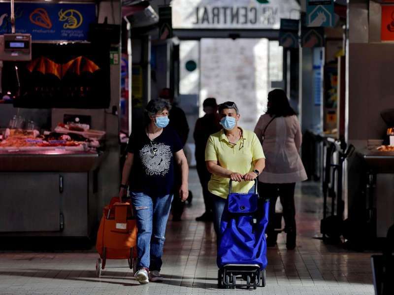 Dos mujeres realizan sus compras con mascarilla. EFE