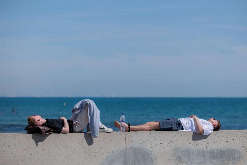 Dos personas descansan al sol en la playa de la Malva-rosa de Valencia. EFE/Biel AliÃ±o/Archivo
