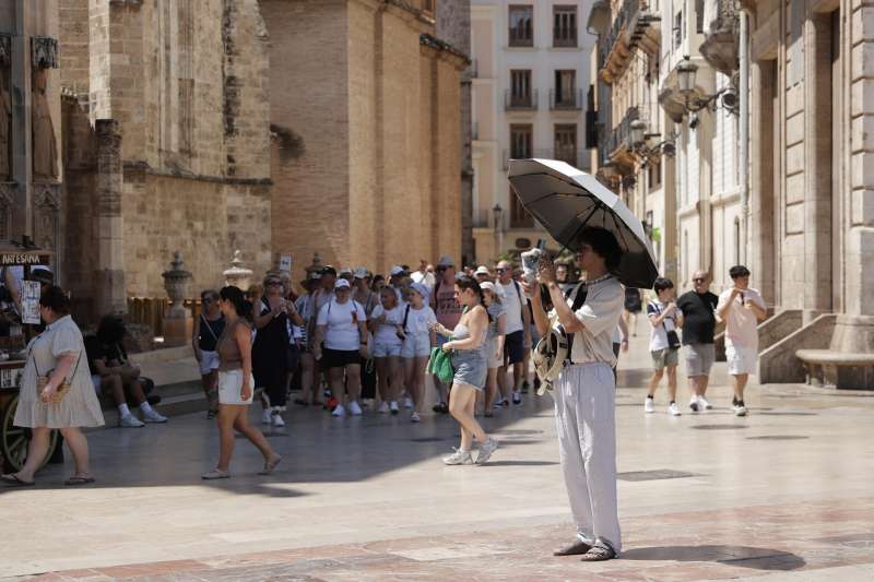 Un turista se protege del sol en la plaza de la Virgen de Valncia. EFEManuel Bruque
