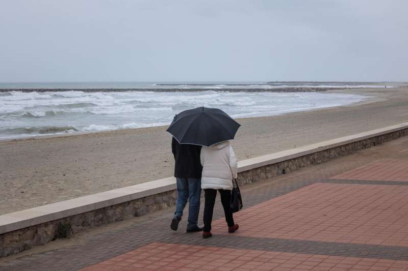 Una pareja se protege de la lluvia con un paraguas. /EFE