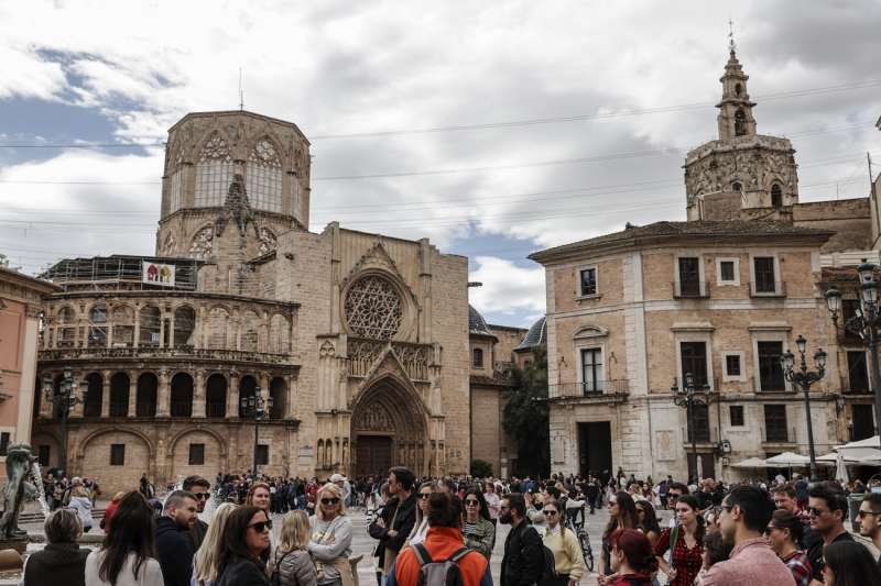 Un grupo de turistas escuchan a su guía en la plaza de la Virgen de València. EFE/Manuel Bruque/Archivo
