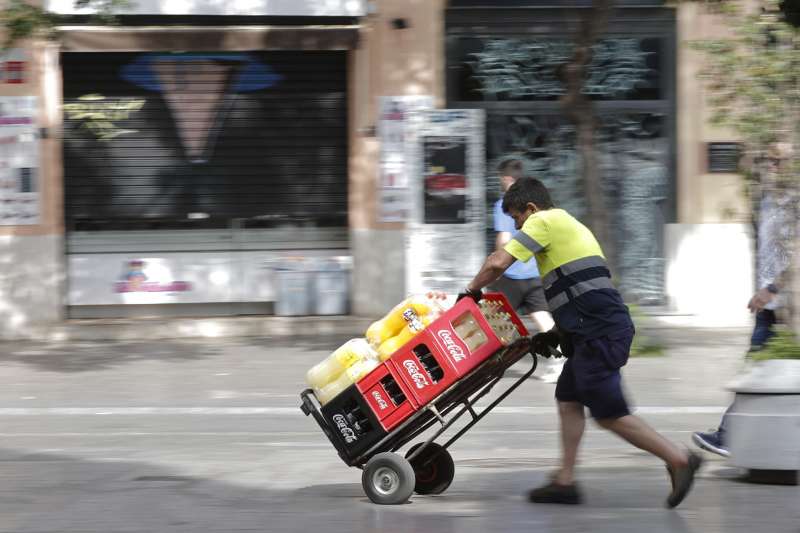 Un trabajador lleva una carretilla repleta de bebida. EFE/Manuel Bruque/Archivo
