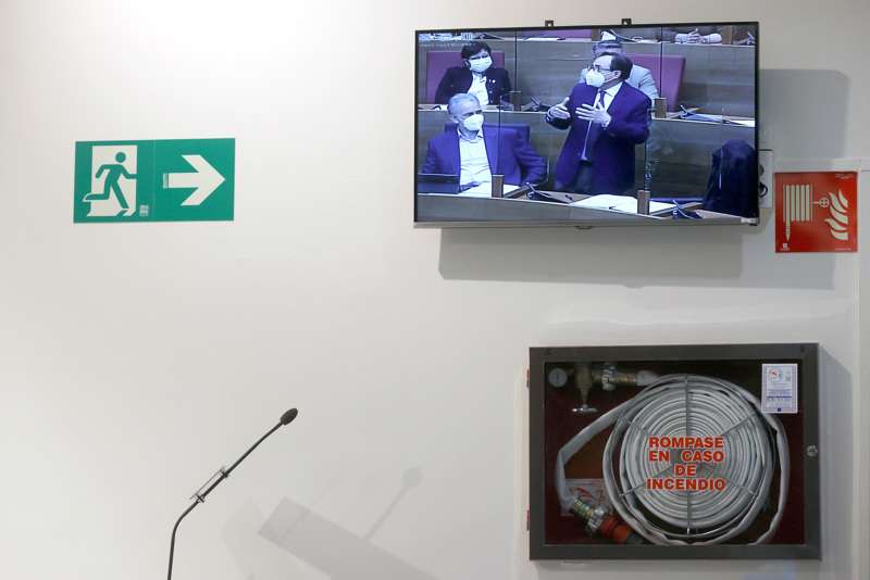  La intervención del conseller de Hacienda, Vicent Soler, reflejada en un monitor de televisión en los pasillos de Les Corts, donde tiene lugar la sesión de control. /EFE