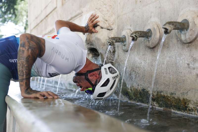 Un ciclista se refresca en una fuente. EFEManuel BruqueArchivo