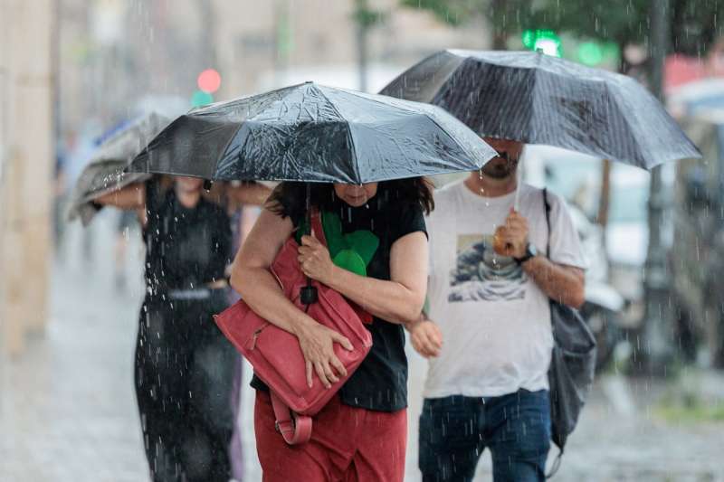 Tres personas caminan bajo la lluvia. EFEBiel AlioArchivo
