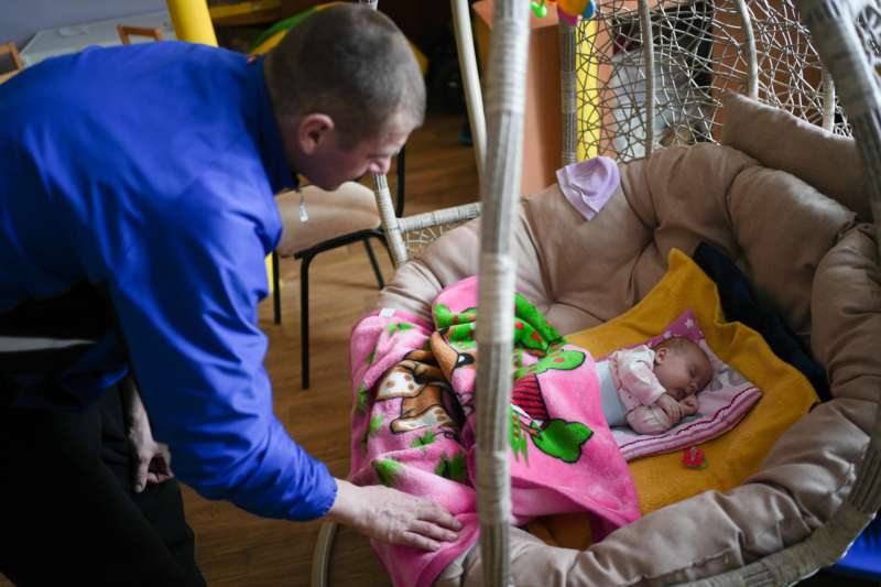 Un hombre acuna a un bebé recién nacido. EFE/Archivo

