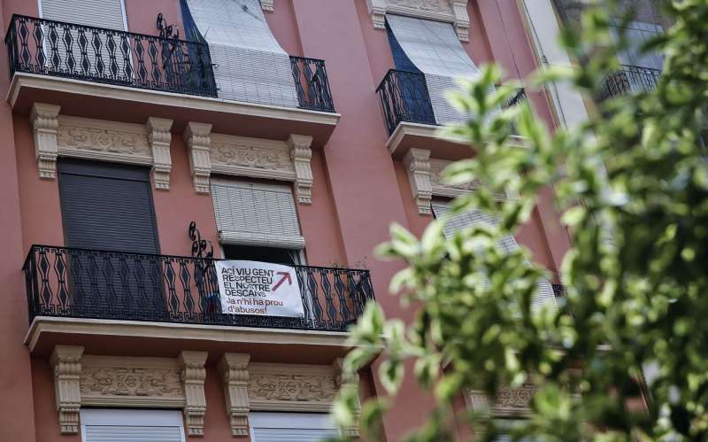 Unos vecinos reclaman, con una pancarta colgada en su balcón, respeto al descanso en un edifico del Barrio de Ruzafa de València. EFE/Manuel Bruque.
