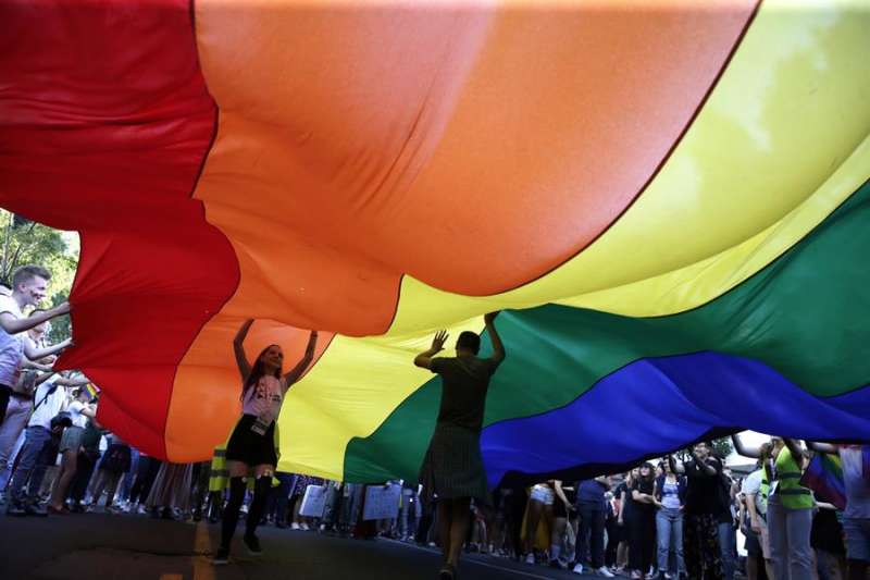 Dos personas caminan bajo una bandera arcoiris en una manifestaci�n del Orgullo. EFE/Archivo