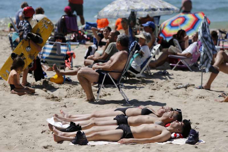Varias personas toman el sol en la playa de Benidorm durante la Semana Santa del año pasado. EFE/Manuel Lorenzo/Archivo
