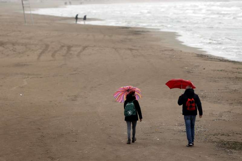 Dos personas pasean por la playa de la Malvarrosa, en Valncia, en un da de lluvia. EFEKai FrsterlingArchivo