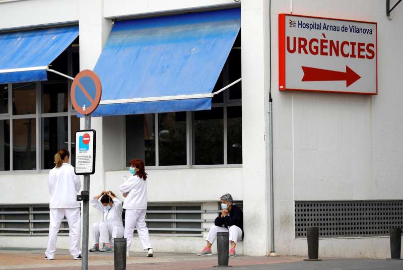 Personal sanitario del Hospital Arnau de Vilanova descansa unos minutos ante la puerta de Urgencias. EFEManuel BruqueArchivo
