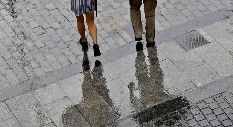 Dos personas caminan protegidos por paraguas de la lluvia. EFEManuel BruqueArchivo
