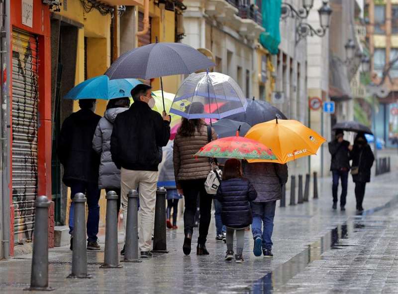 Un grupo de personas pasea un día lluvioso por València. EFE/Manuel Bruque/Archivo
