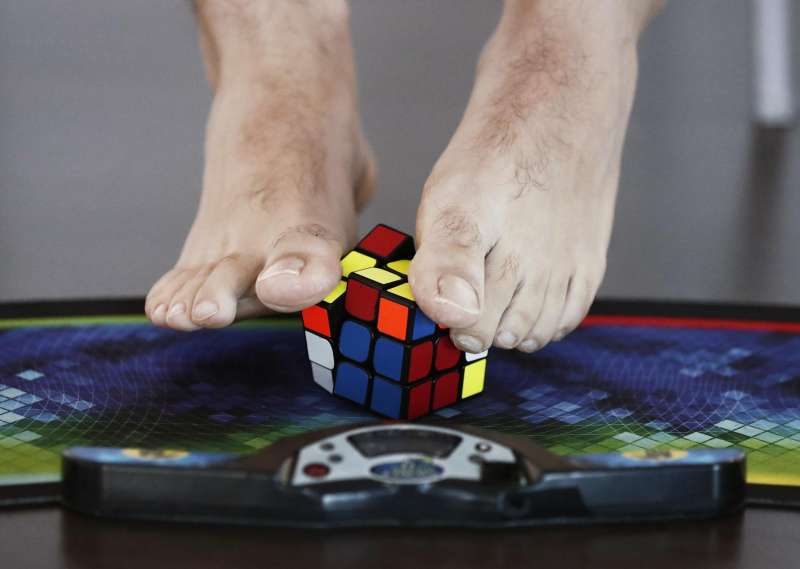 Una persona completa un cubo de Rubik con los pies. EFE/Jesús Diges/Archivo