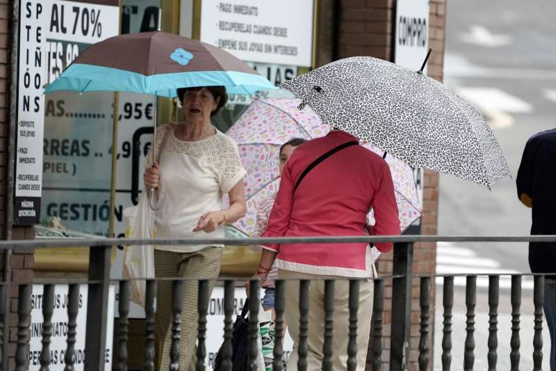 Tres personas se protegen con paraguas de la lluvia. EFEPaco Paredes