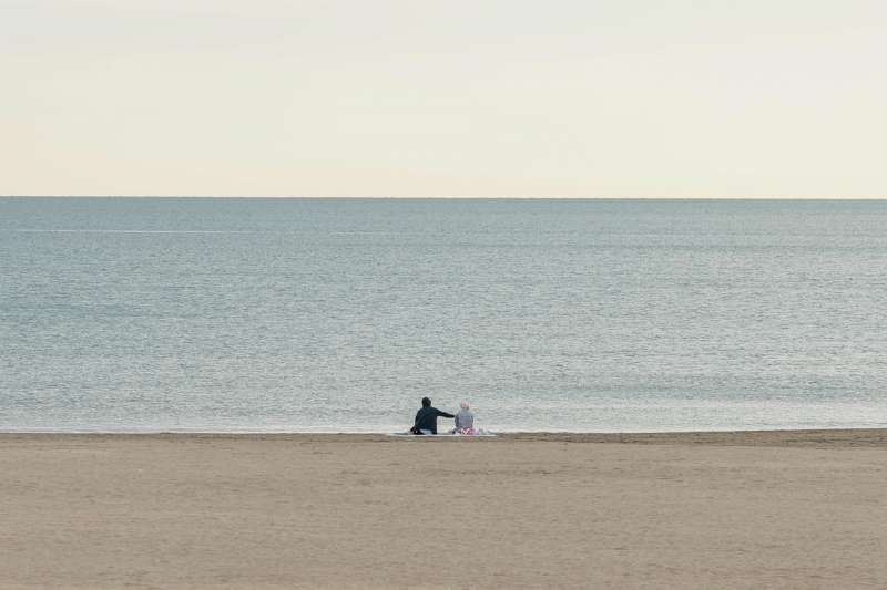 Dos personas disfrutan de la tranquilidad de la playa de la Malvarrosa. EFE/Biel Aliño/Archivo