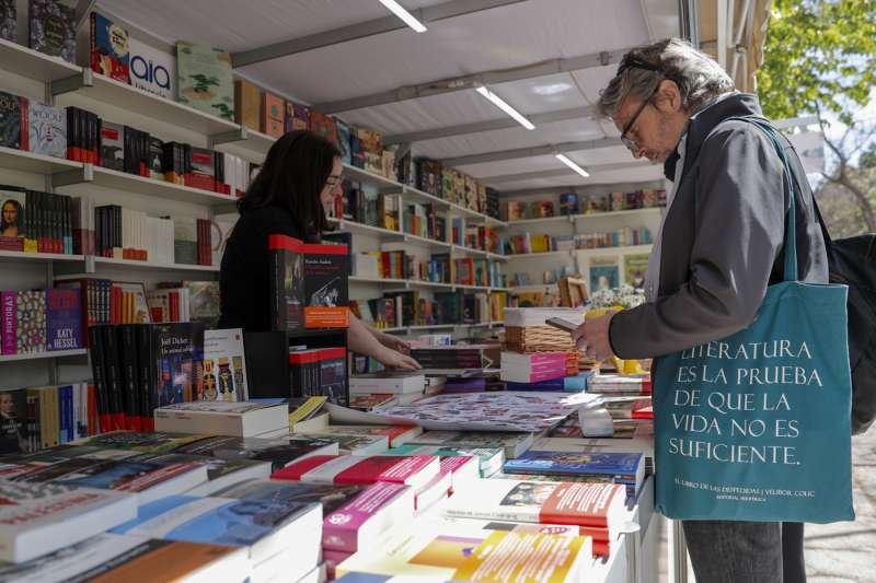Una persona recorre una de las casetas de la 59ª Feria del Libro de València, organizada por la Fundació Fira del Llibre de València y el Gremi de Llibrers de València, que se inaugura este jueves en los Jardines del Real. EFE/Manuel Bruque
