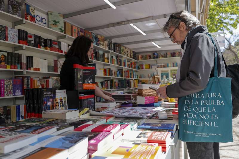 Una persona recorre una de las casetas de la 59 Feria del Libro de Valncia, organizada por la Fundaci Fira del Llibre de Valncia y el Gremi de Llibrers de Valncia, que se inaugura este jueves en los Jardines del Real. EFE/Manuel Bruque
