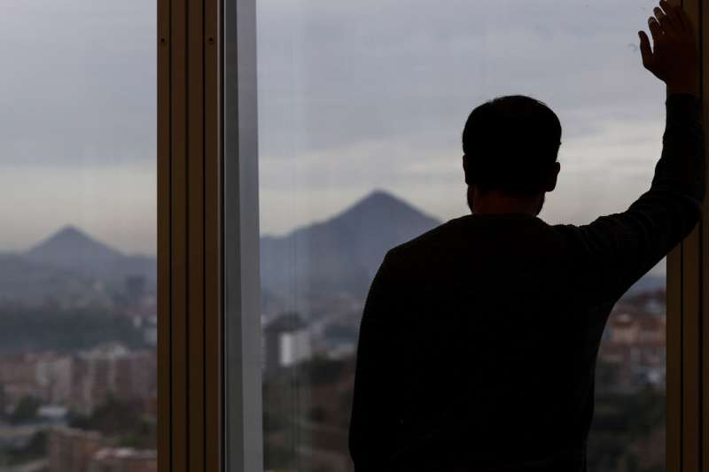 Un hombre mira por la ventana de su oficina. EFEMiguel Toa
