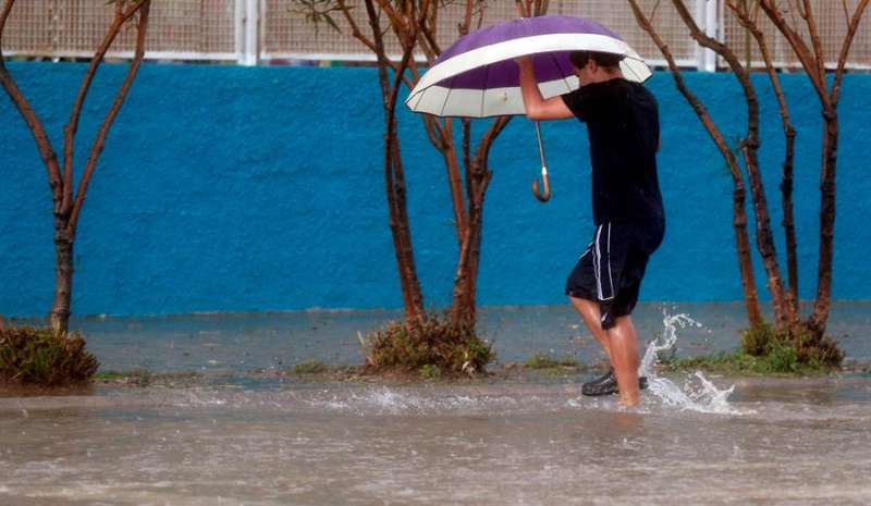 Una persona vadea una calle este viernes cuando las provincias de Castellón y Valencia están en alerta naranja por precipitaciones de intensidad muy fuerte y con tormenta. EFE/Kai Försterling
