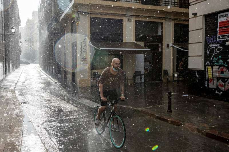 Una persona circula en bicicleta bajo una fuerte tromba de agua. EFE/Biel AliÃ±o
