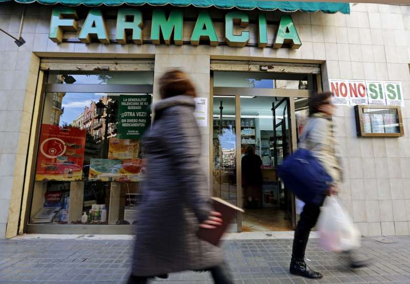 Dos personas pasan ante una farmacia. EFEManuel BruqueArchivo
