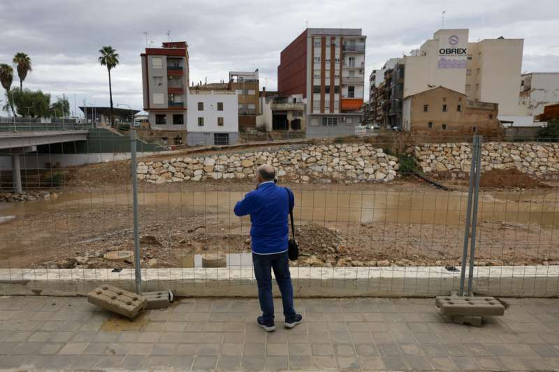 Un vecino contempla el barranco del Poyo a su paso por Paiporta  EPDA