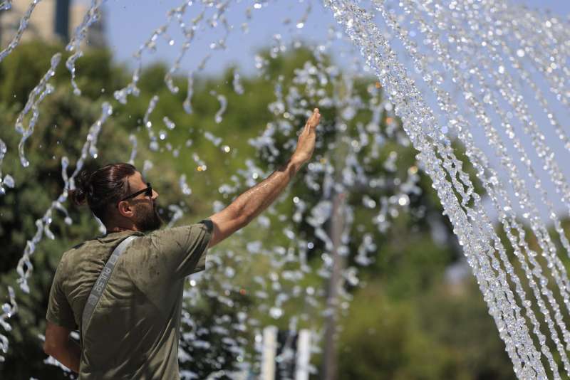 Un hombre se refresca en una fuente  Foto: EFE Kai Frsterling
