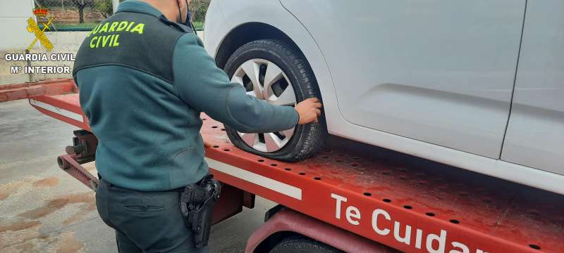 Un agente de la Guardia Civil inspecciona la rueda pinchada de uno de los vehículos afectados. / EPDA 