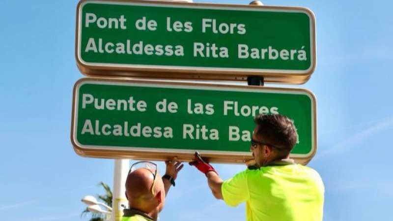 Operarios cambiando el nombre del Puente de las Flores de Valencia este viernes. /EPDA