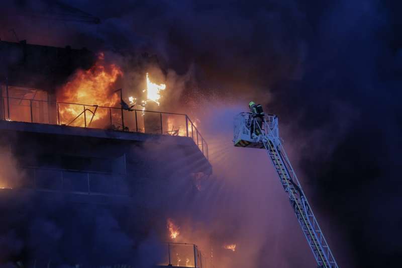 Bomberos trabajan en el incendio declarado sobre las cinco y media de esta tarde en un quinto piso de un edificio de viviendas de Valencia que ha afectado totalmente al inmueble y se ha propagado a otro anexo. EFE/Manuel Bruque
