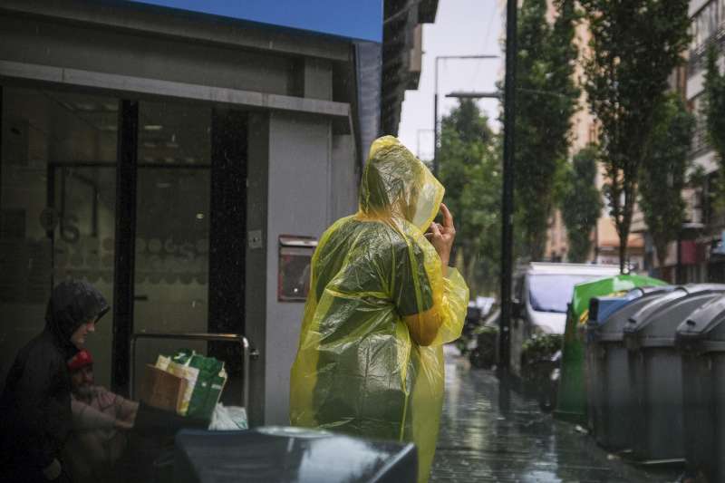 Una persona se protege de la lluvia en Alicante. EFE  Pablo MiranzoArchivo
