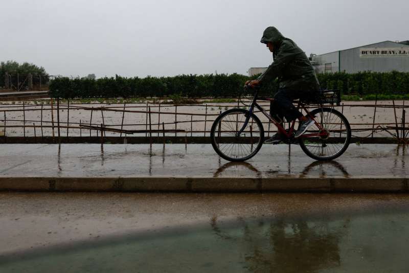 Un ciclista pedalea bajo la lluvia. EFE Kai Frsterling
