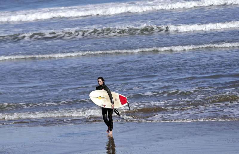 Una surfista sale del agua en la playa de la Malvarrosa, en Valencia. EFE/Manuel Bruque/Archivo
