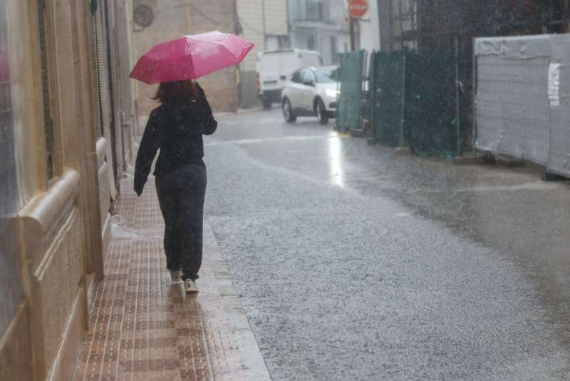 Una persona se protege de la lluvia con un paraguas en Almussafes (Comunidad Valenciana) este sbado. EFE Kai Frsterling