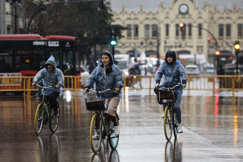 Varias personas circulan en bici con chubasquero en un d�a de lluvia en Val�ncia. EFEBiel Ali�o