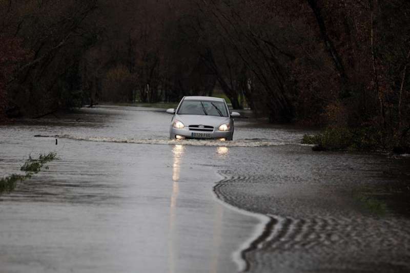 Un coche cruza una carretera anegada por las lluvias. . EFE/Archivo