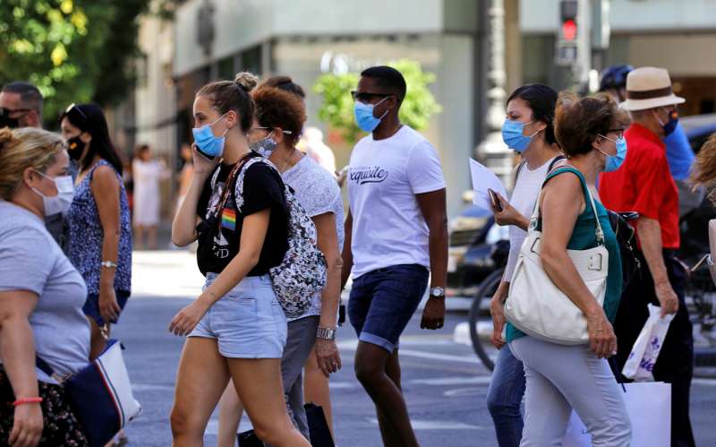 Varias personas cruzan un paso de peatones en una calle de València, con mascarilla en 2021, con algunas restricciones. EFE/Manuel Bruque/Archivo

