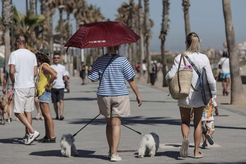 Varias personas pasean junto a la playa. EFE/Manuel Bruque/Archivo
