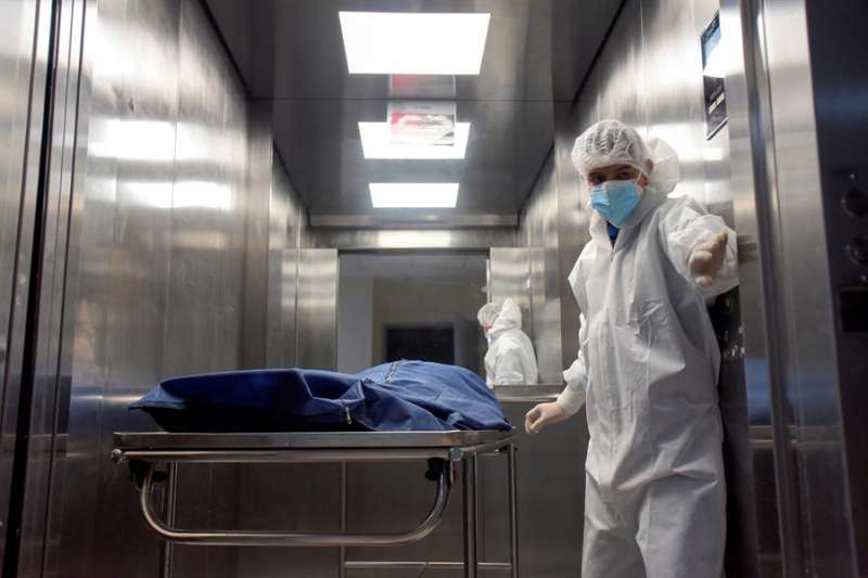 Personal de salud traslada a un paciente fallecido por la Covid-19. EFE/Archivo
