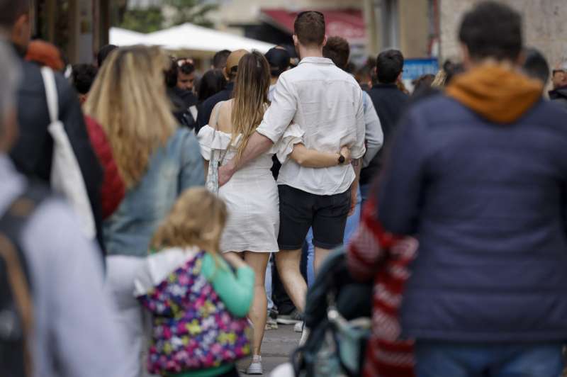 Imagen de archivo de una pareja con atuendo veraniego paseando entre una multitud abrigada por el centro de Valncia. EFE/Ana Escobar