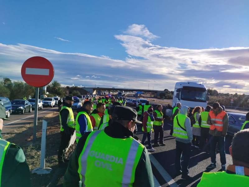 Agentes de la Guardia Civil de Tráfico y agricultores en protesta en la retención de hoy en la A-3 en Chiva, Valencia. EFE/M.G.
