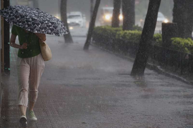Una mujer camina por la acera bajo una intensa lluvia este sábado en Valencia.EFE/ Juan Carlos Cárdenas/Archivo